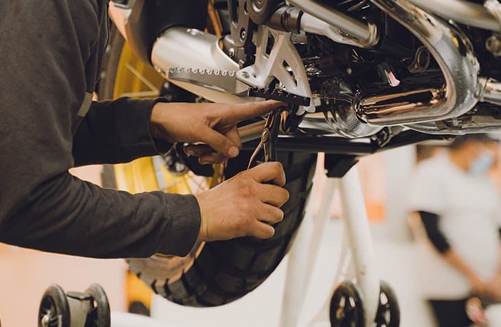 Mecánico especializado realizando mantenimiento preventivo en motocicleta BMW en taller Motorent